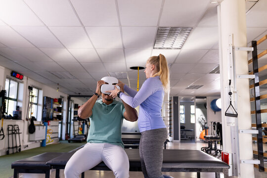 Diverse physical therapist colleagues assisting in gym rehabilitation center