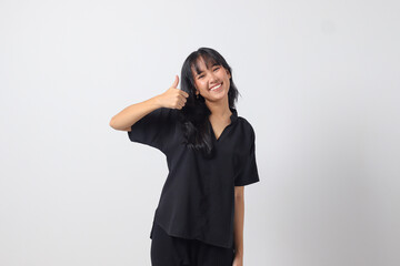Portrait of attractive Asian woman in casual shirt making thumb up hand gesture, saying good job....