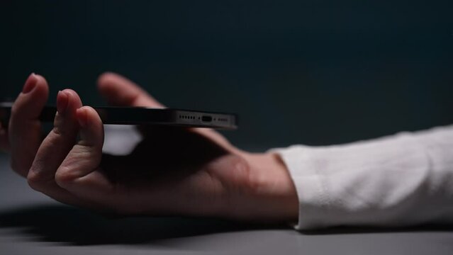 Close-up hand of unrecognizable woman unplugging type-c cable from mobile phone after charge. EU law to force USB-C chargers. Closeup female hand disconnect cable to smartphone, slow motion.