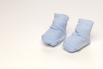 baby socks, for newborns, the first shoes with delicate feet on a light background