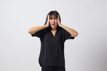 Portrait of attractive Asian woman in casual shirt making shocked hand gesture, showing surprised and scared expression. Isolated image on white background