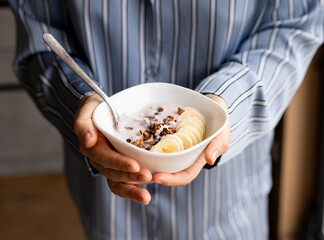 healthy breakfast, a bowl with granola, banana slices and yogurt