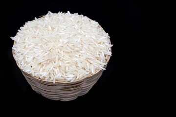 Uncooked Basmati Rice in a Small Bamboo Basket Isolated on Black Background with Copy Space