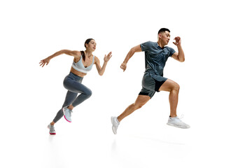 Side view dynamic photo of woman and man in mid-run, demonstrating their athletic prowess against white studio background. Concept of people in sport, healthy lifestyle, teamwork, motivation. Ad