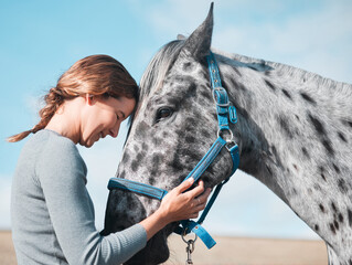 Happy, woman and calm horse on farm for equestrian, training or adventure in countryside. Girl,...