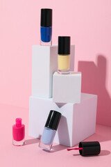 Multicolored nail polishes with white wooden cubes