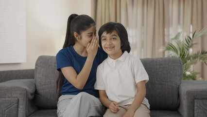 Indian sister telling a secret to her brother