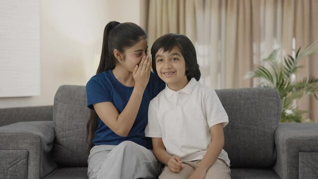Indian sister telling a secret to her brother