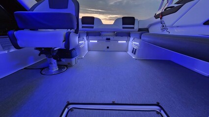 Interior view of a boat with blue neon lights at sunset
