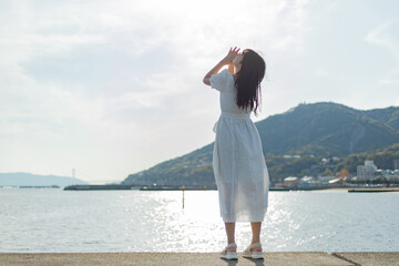 海ではしゃいでいる白いワンピースの女性