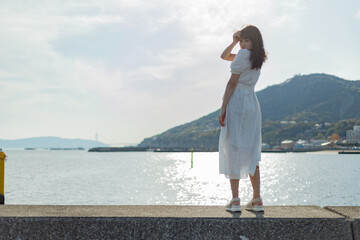 海ではしゃいでいる白いワンピースの女性