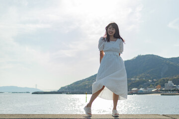 海ではしゃいでいる白いワンピースの女性