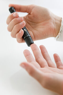 Close up of Woman's Hands Using Glucose Meter
