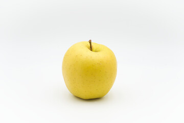 Yellow apple on a white surface