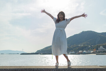 海ではしゃいでいる白いワンピースの女性