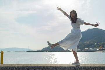 海ではしゃいでいる白いワンピースの女性