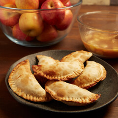 Wooden table with fried apple pastries