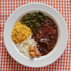 Feijoada dish with rice, farofa, cabbage and crackling