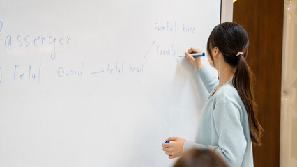 A girl is writing on a white board