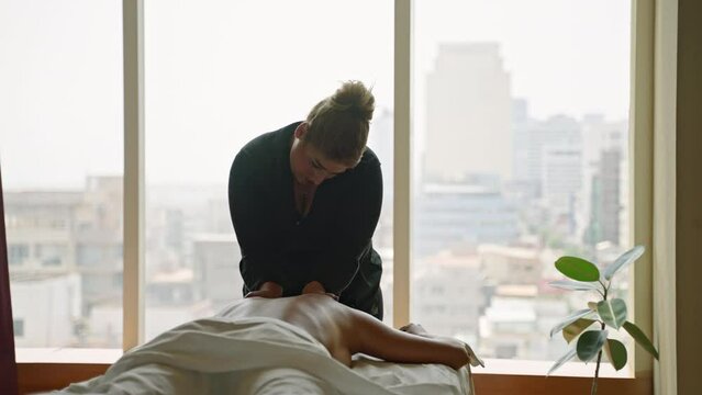 Woman masseuse in a luxury spa center does oil upper body massage to a young tanned client. Female wellness center employee performs a relaxing body care procedure to a girl, releases trigger points