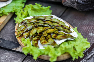 Wooden Plate With Lettuce Covered in Sauce