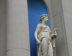 Fototapeta premium White Statue of Goddess Chloris in a Blue Niche in the Garden of a Canal House in Amsterdam, Netherlands
