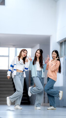 Three girls are posing for a picture in a hallway