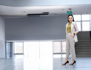 A woman in a business suit stands in a hallway