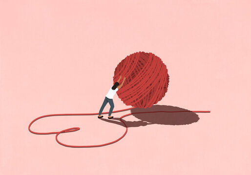 Woman pushing large ball of red string forming heart-shape on pink background

