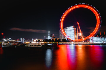 Obraz premium Large illuminated ferris wheel against a backdrop of colorful lights, London, UK