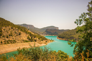 Turquoise blue lake surrounded by trees and mountains