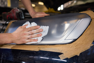 Person using a machine to polish automotive lighting on a car headlight