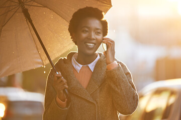 Business, black woman and phone call with umbrella in outdoor rain for communication, walk and...
