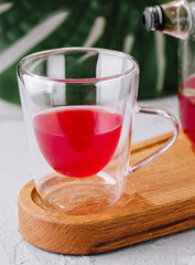 Freshly brewed hibiscus tea in glass teapot and cup