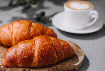 Fresh croissants and coffee on table