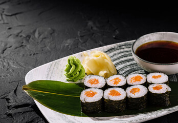 Exquisite sushi platter with soy sauce on dark background