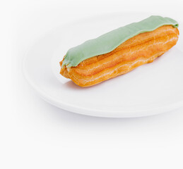 Fresh pistachio eclair on white plate