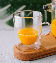 Freshly blended orange smoothie in glass and pitcher