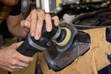 Person using a machine to polish automotive lighting on a car headlight