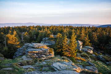 View from mountain summit known as Vozka in natural parkland Jeseniky mountains, Czech Republic. Sunrise in nature. Rock formation in forest and hills