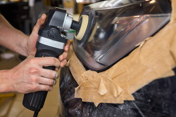 Person using a machine to polish automotive lighting on a car headlight