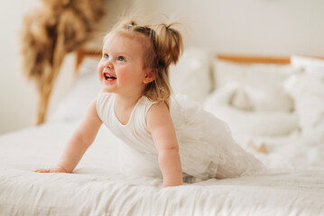 Cute adorable baby girl in white dress indoors closeup portrait Happy childhood funny kid