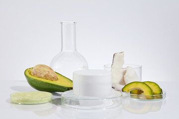 The white color blank label cosmetic jar displayed on glass pedestal in center, yellow exfoliation...