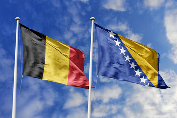 3d illustration. Belgium and Bosnia and Herzegovina Flag waving in sky. High detailed waving flag. 3D render. Waving in sky. Flags fluttered in the cloudy sky.