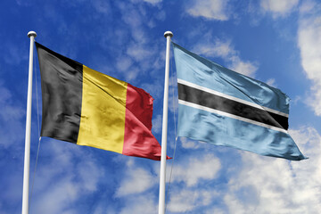 3d illustration. Belgium and Botswana Flag waving in sky. High detailed waving flag. 3D render. Waving in sky. Flags fluttered in the cloudy sky.