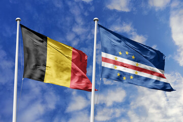 3d illustration. Belgium and Cabo Verde Flag waving in sky. High detailed waving flag. 3D render. Waving in sky. Flags fluttered in the cloudy sky.