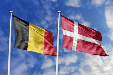 3d illustration. Belgium and Denmark Flag waving in sky. High detailed waving flag. 3D render. Waving in sky. Flags fluttered in the cloudy sky.