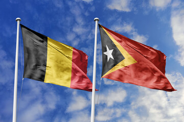 3d illustration. Belgium and East Timor Flag waving in sky. High detailed waving flag. 3D render. Waving in sky. Flags fluttered in the cloudy sky.