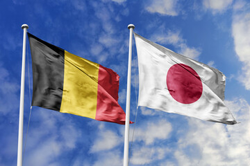 3d illustration. Belgium and Japan Flag waving in sky. High detailed waving flag. 3D render. Waving in sky. Flags fluttered in the cloudy sky.