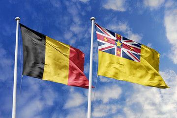 3d illustration. Belgium and Niue Flag waving in sky. High detailed waving flag. 3D render. Waving in sky. Flags fluttered in the cloudy sky.